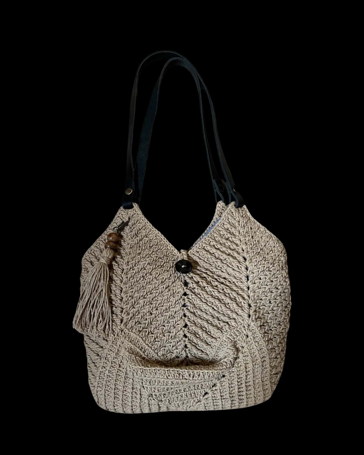 Bolsa Dubai cor areia em crochê de barbante, com tassel e alças tipo couro preto, foto de catálogo em fundo neutro