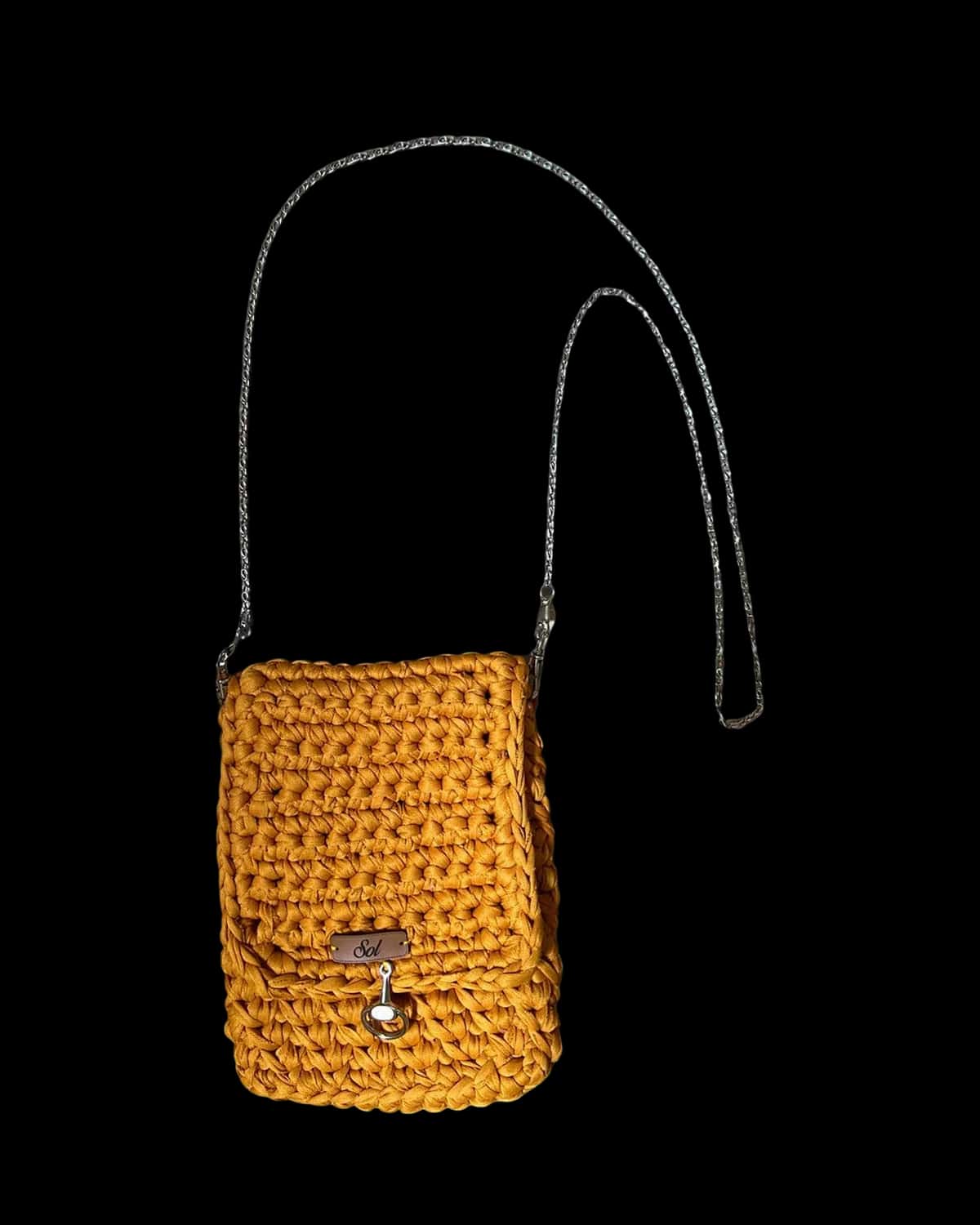 Bolsa Marrakech mostarda, porta-celular em crochê com corrente fina, foto de catálogo em fundo neutro