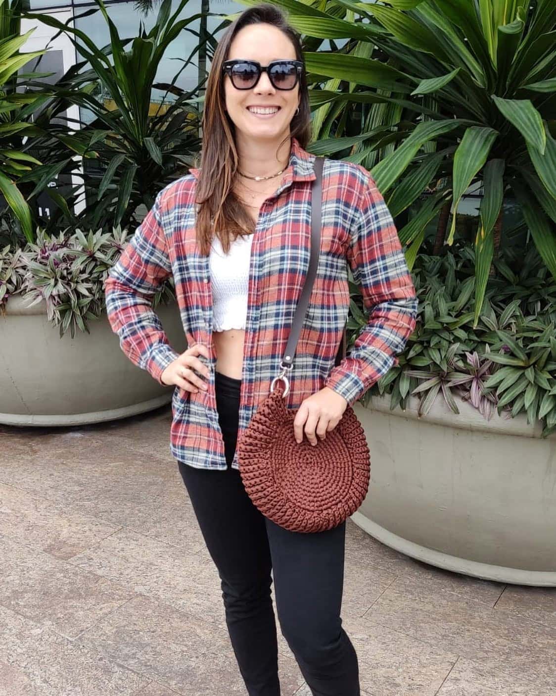 Cliente de camisa xadrez com a bolsa Paraty marrom a tiracolo